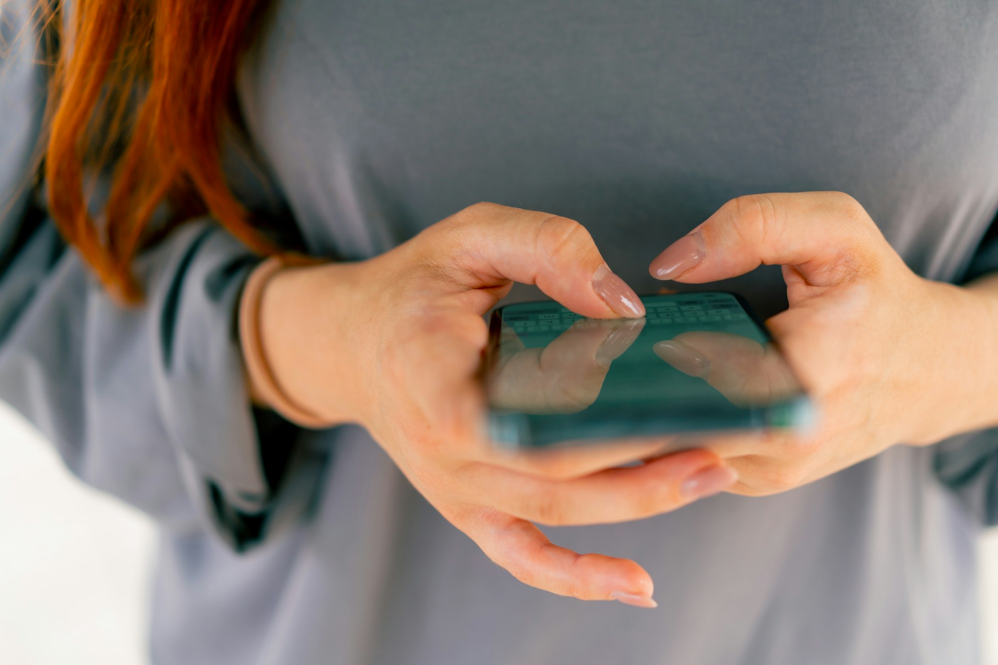 close-up of female hands holding a smartphone texting with a girlfriend or a friend in messenger